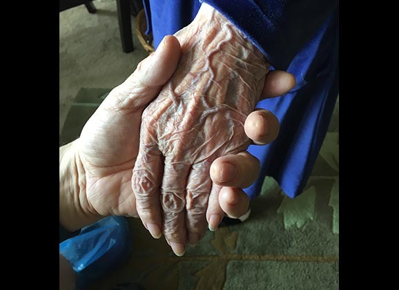 Holding the hand of a person of age