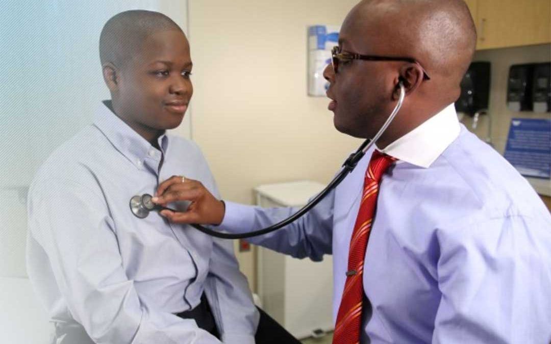 Doctor listening to patients heart with stethoscope.
